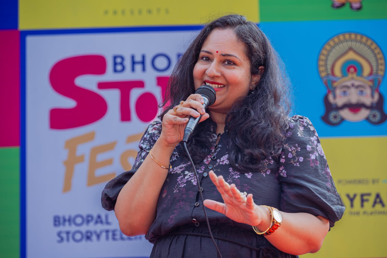 Mona Ghai telling stories on stage at a storytelling festival
